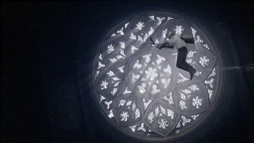 a person is flying through a circular window with a stained glass design