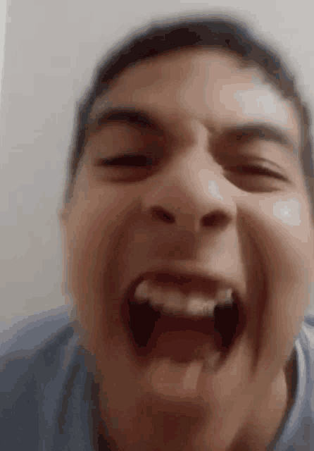 a close up of a man 's face with his mouth open