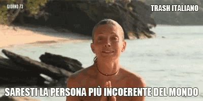 a woman without a shirt is standing on a beach with a caption in italian .