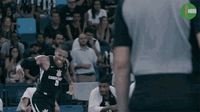 a basketball player in a corinthians jersey stands in front of a referee