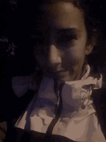 a close up of a person 's face with a white shirt and tie