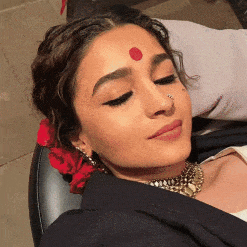 a woman with a red dot on her forehead and a nose ring