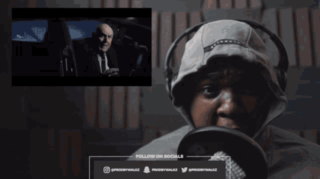 a woman wearing headphones is crying in front of a screen that says follow on socials on it