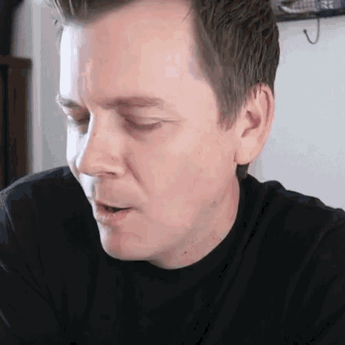a close up of a man 's face with his eyes closed and his mouth open .