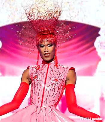 a woman in a pink dress with red gloves and a red hat