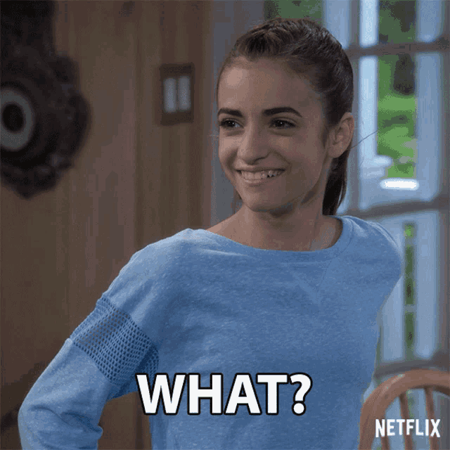a woman in a blue shirt is smiling and says what netflix