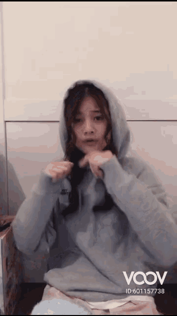 a woman wearing a grey hoodie has a vcov id on the bottom right