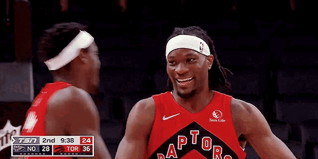 two basketball players hugging each other in front of a sprite sign