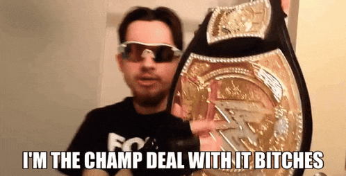a man wearing sunglasses is holding a wrestling championship belt with the caption i 'm the champ deal with it bitches