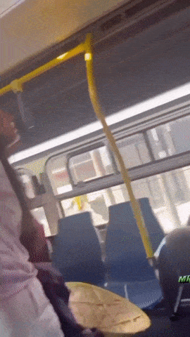 a person sitting on a bus with the word mr. on the back seat