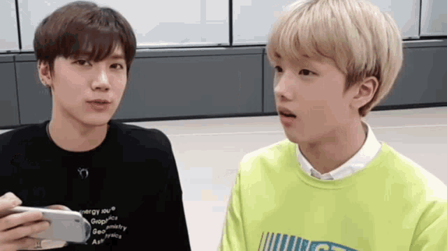 two young men are standing next to each other and one is wearing a black shirt that says energy on it