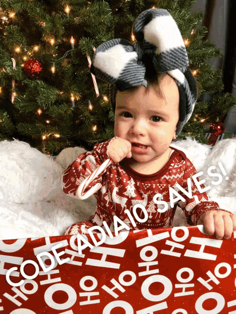 a baby is holding a candy cane in front of a christmas tree with the words code a dia 10 saves