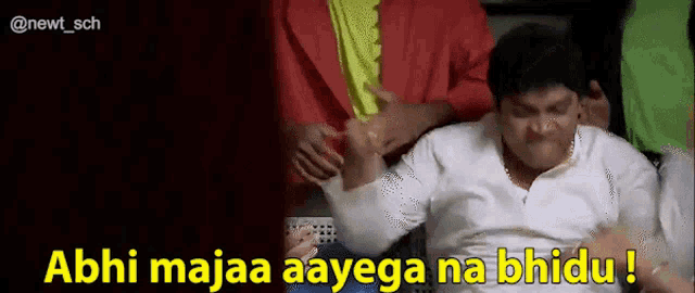 a man is sitting in a chair with the words abhi majaa aayega na bhideu