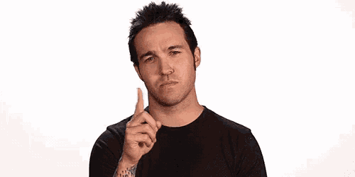 a man wearing a black shirt is pointing up with his finger .