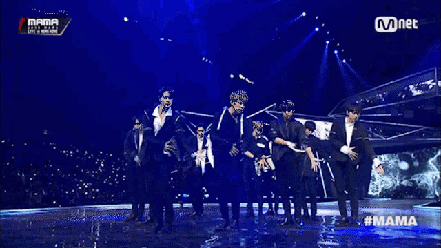 a group of young men are dancing on a stage with the words mama on the bottom