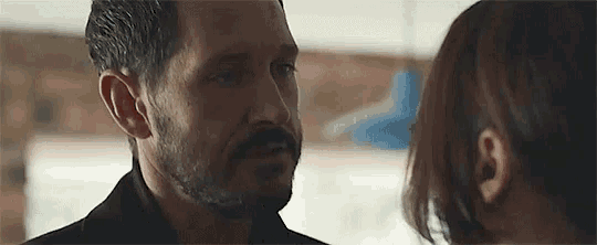 a man with a beard and a woman are looking at each other in a room .