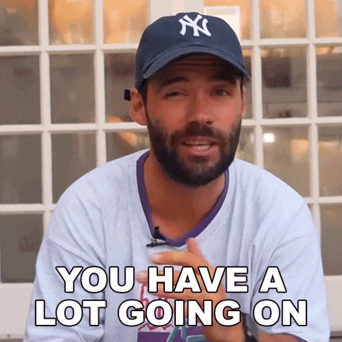 a man with a beard wearing a ny yankees hat says you have a lot going on
