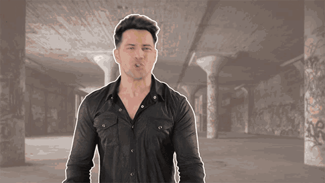 a man in a black shirt is standing in an empty room