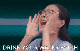 a woman wearing glasses is screaming with the words drink your water bitch behind her