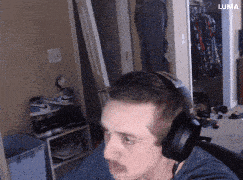 a man wearing headphones is sitting in a room with the word luma in the corner