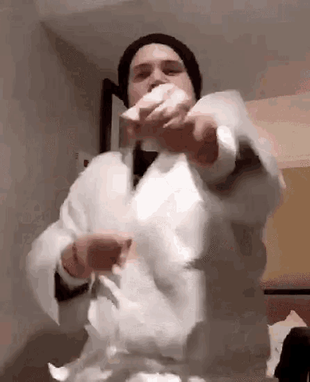 a man in a white coat is holding a roll of toilet paper .