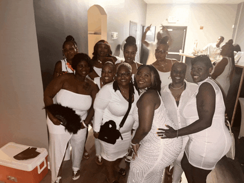 a group of women are posing for a photo in a hallway