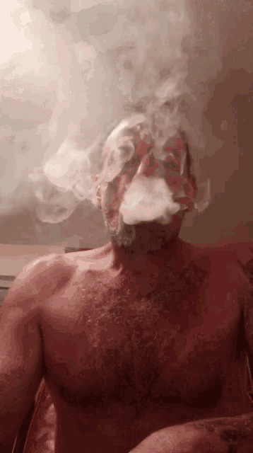 a shirtless man smoking a cigarette with smoke coming out of his face