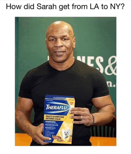 a man holding a box of theraflu medicine