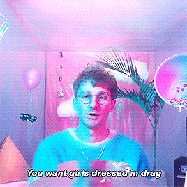 a man wearing glasses and a blue sweater says you want girls dressed in drag