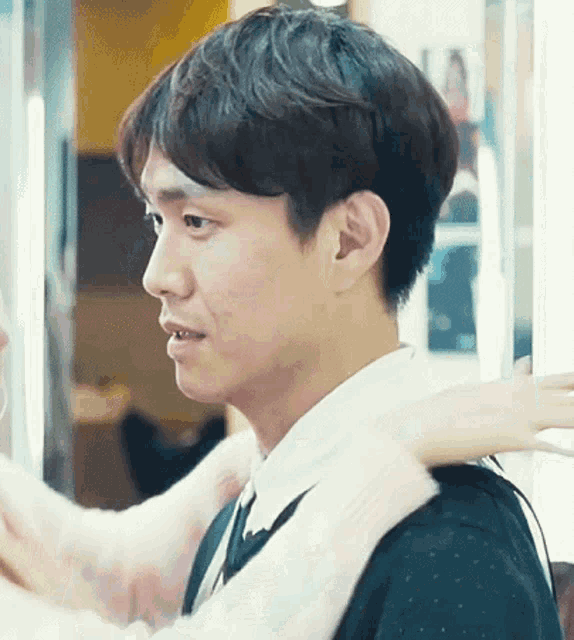 a close up of a man 's face with a woman 's arm around him