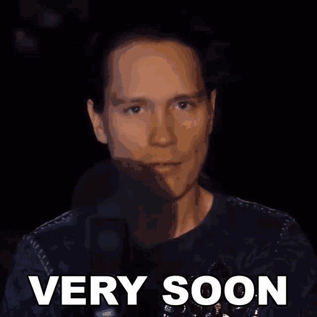 a man says very soon in front of a black background