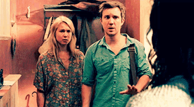 a man and woman are standing next to each other in a hallway .