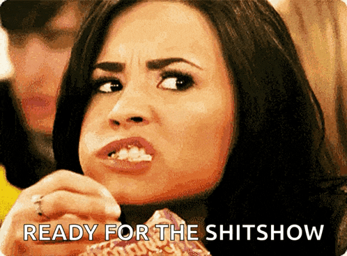 a woman eating popcorn with the words " ready for the shitshow " behind her