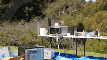 a microwave sits on a table in a field