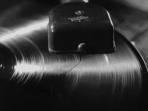 a black and white photo of a record being played on a phonograph