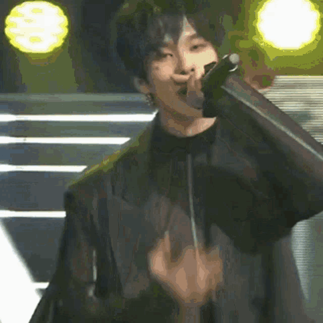 a man is singing into a microphone on stage