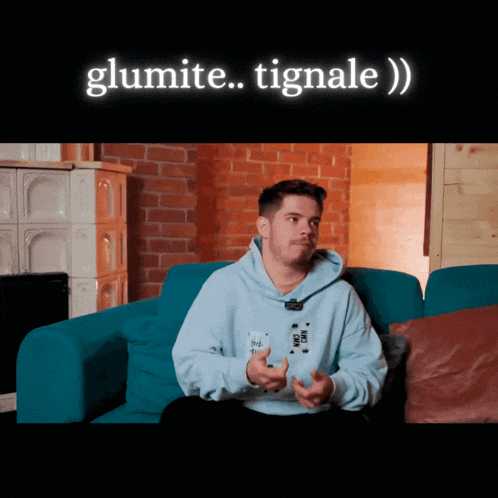 a man sitting on a blue couch with the words glumite tignale written on the bottom