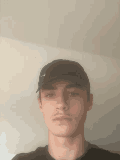 a young man wearing a black hat with the word nike on it