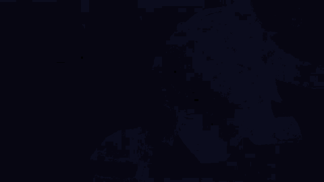 a close up of a person 's hand on another person 's knee in a dark room .