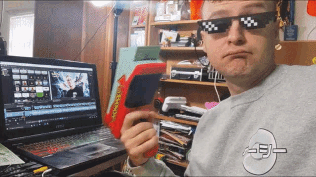 a man wearing sunglasses is sitting in front of a msi laptop computer