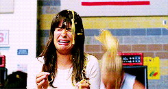 a woman is crying while holding a piece of spaghetti
