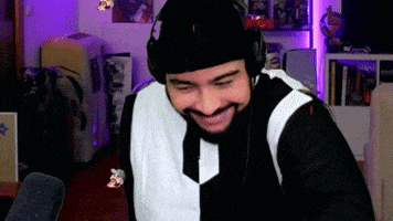 a man with a beard is wearing headphones and a beanie and smiling .