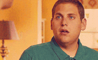 a man in a green shirt is making a surprised face