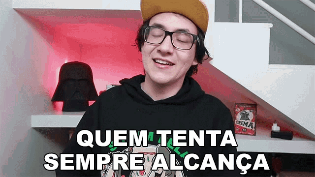 a man wearing glasses and a hat is smiling and says quem tenta sempre alcanca