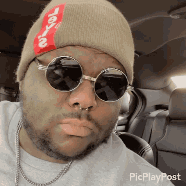 a man wearing sunglasses and a beanie with the word levi 's written on it