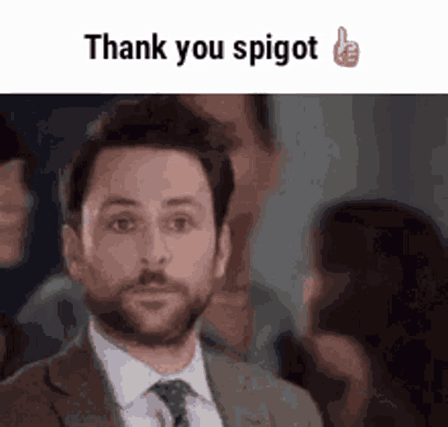 a man in a suit and tie is giving a thumbs up in a crowd of people .