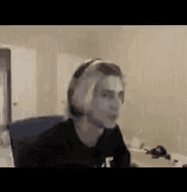 a man wearing headphones is sitting in a chair in front of a computer screen .