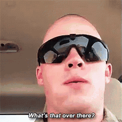 a bald man wearing sunglasses is asking what 's that over there .