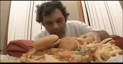 a man is eating a hamburger and french fries on a table
