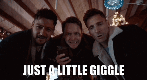 three men are looking at a cell phone with the words just a little giggle below them